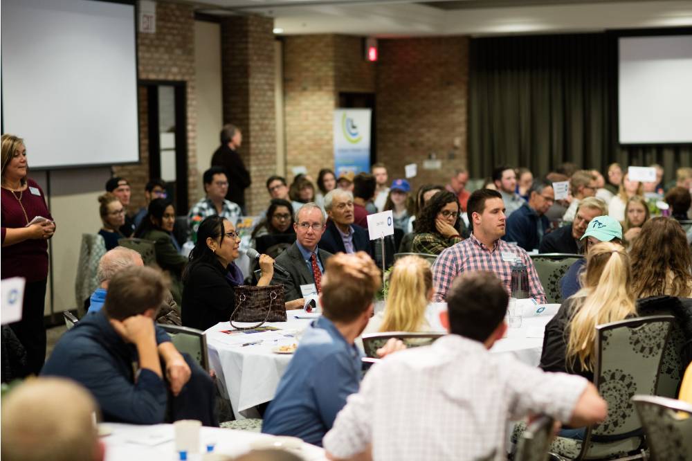 Image 1 of 30 An attendee shares a story and asks a question to the panel.